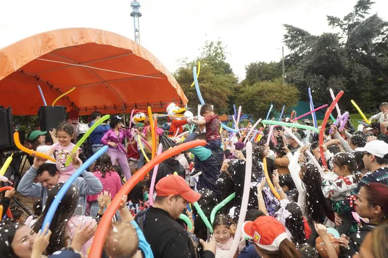 Lluvia de globos largos sobre el público frente a la tarima