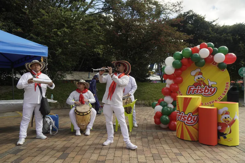 Músicos con trajes blancos y sombreros tocando junto a la decoración de Frisby