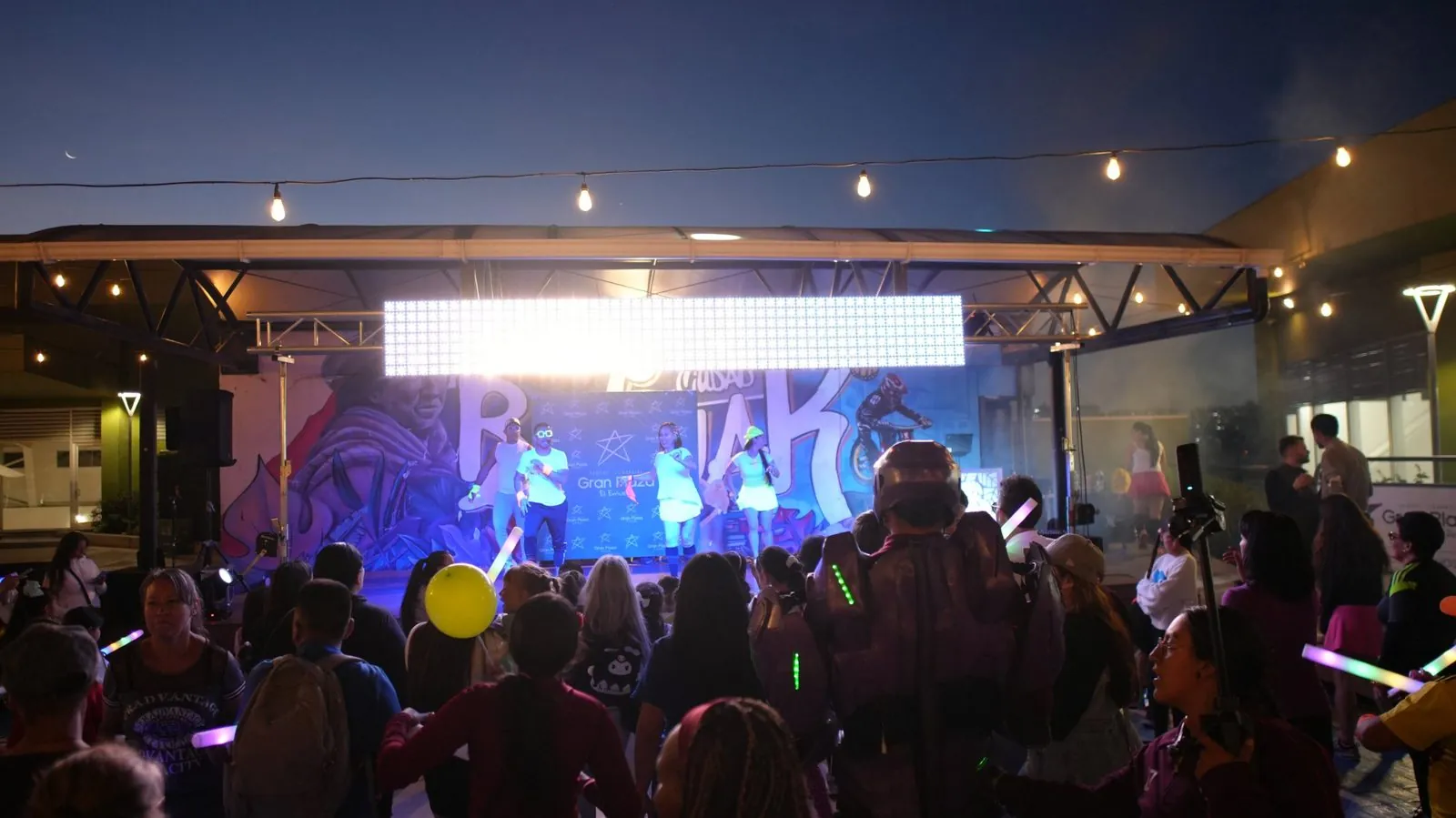 Show nocturno al aire libre con pantalla LED y luces de neón