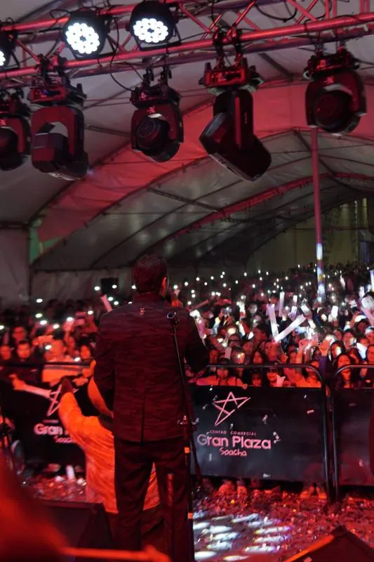 Público con las luces de los celulares encendidas dentro de la carpa
