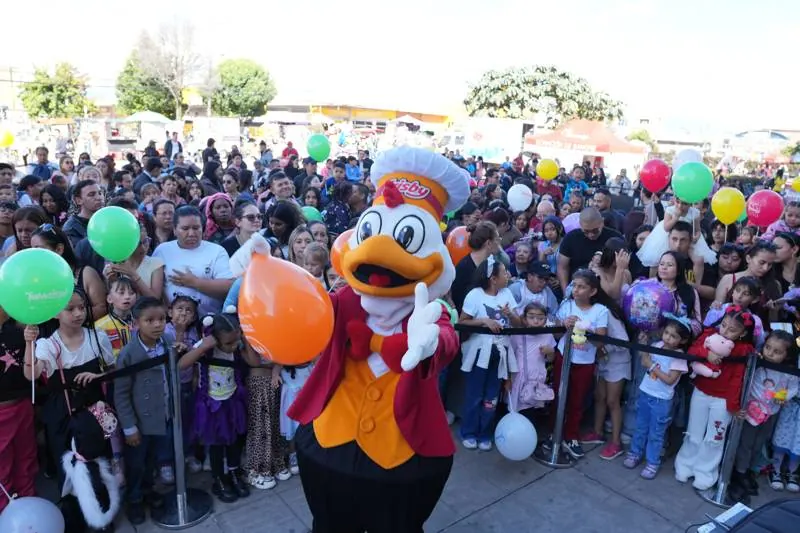 Mascota saludando al público reunido frente a la tarima