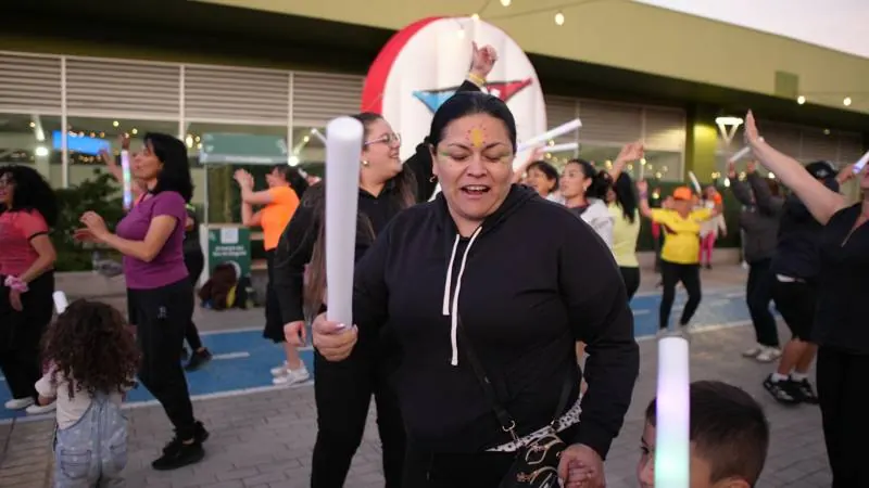 Asistentes bailando con tubos LED