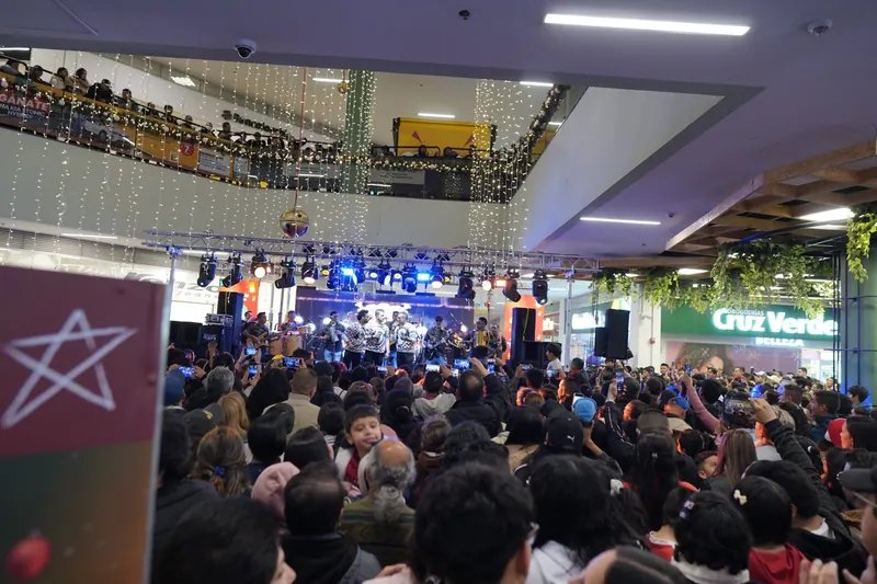 Concierto de Navidad con la tarima iluminada y el público en varios niveles