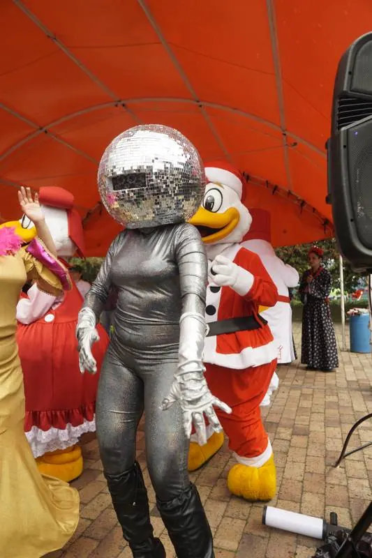 Personaje con cabeza de bola de espejos junto a las mascotas navideñas