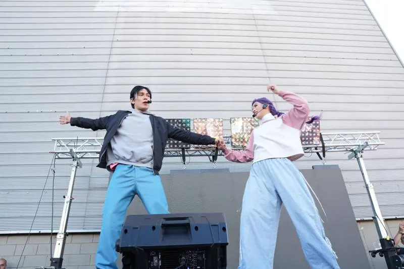 Pareja de bailarines de K-pop en la tarima al aire libre