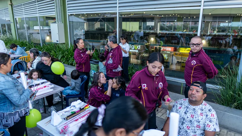 Equipo de Quantum con chaquetas de la marca atendiendo mesas de actividades con el público