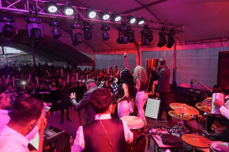 La banda en tarima bajo luces rosadas